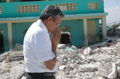 12 febbraio 2010 - Don Pascual Chvez, Rettor Maggiore in preghiera nel luogo dove sono ancora sepolte sotto le macerie 150 vittime del terremoto tra allievi e insegnanti della scuola ENAM. 

