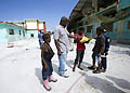 22 gennaio 2010 - Don Pierre Lephène davanti alle rovine dell`opera salesiana Enam con alcuni bambini di strada.